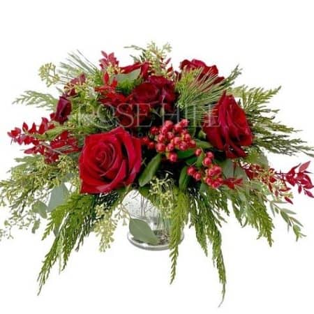Lovely holiday centerpiece with red roses and winter greens. Add a holiday candle for that extra special holiday touch!