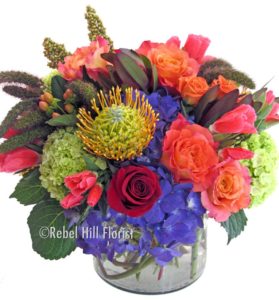 pin cushion protea orange roses purple and green accents in glass cube