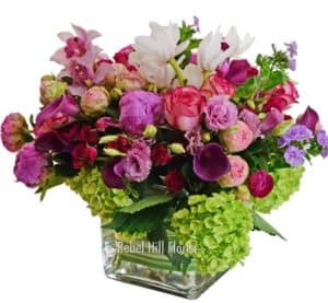 A stunning cluster of premium flowers in a clear cube