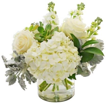 The elegant and classic arrangement of shades of white and green hydrangea, roses, stock and dusty miller would make a great surprise for that someone special!
