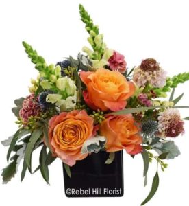 This arrangement comes in a black cube container, featuring soft tones and a burst of free spirit roses.