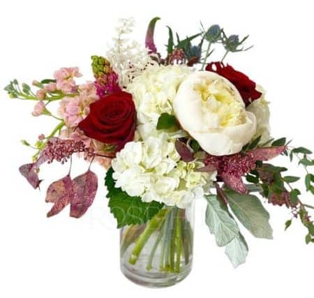 Elegant cylinder arrangement featuring red roses, hydrangea, veronica, peony, hyacinth, and more! The blush tones speak "romance"!